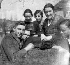 Group shot outdoors: three young ladies sitting on a low wall, three young  men scrunched close against them in the foreground.