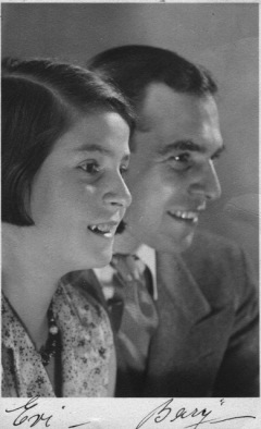 Three-quarter profile of young woman and man close together smiling .